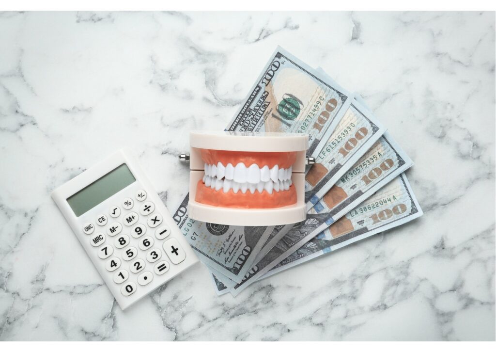 Teeth model with cash and calculator, Medicare and Medicaid dental costs