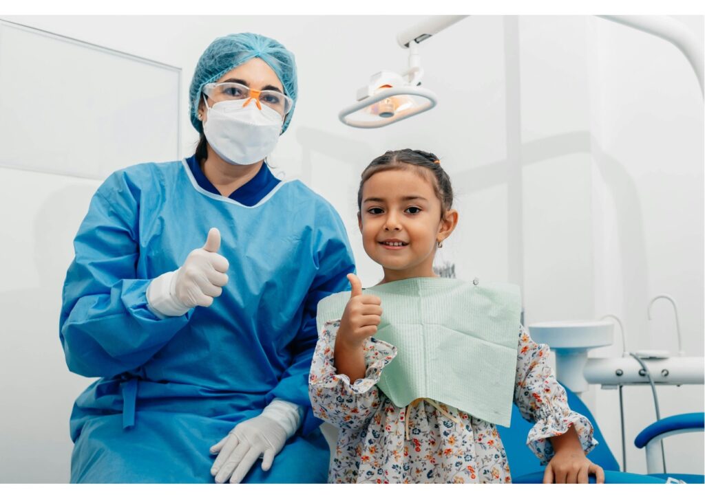 Child and dentist smiling after exam, early dental care for kids