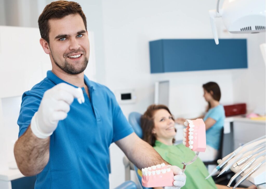Dentist explaining treatment options to a patient using a dental model, helping identify and treat an infected tooth before complications develop.