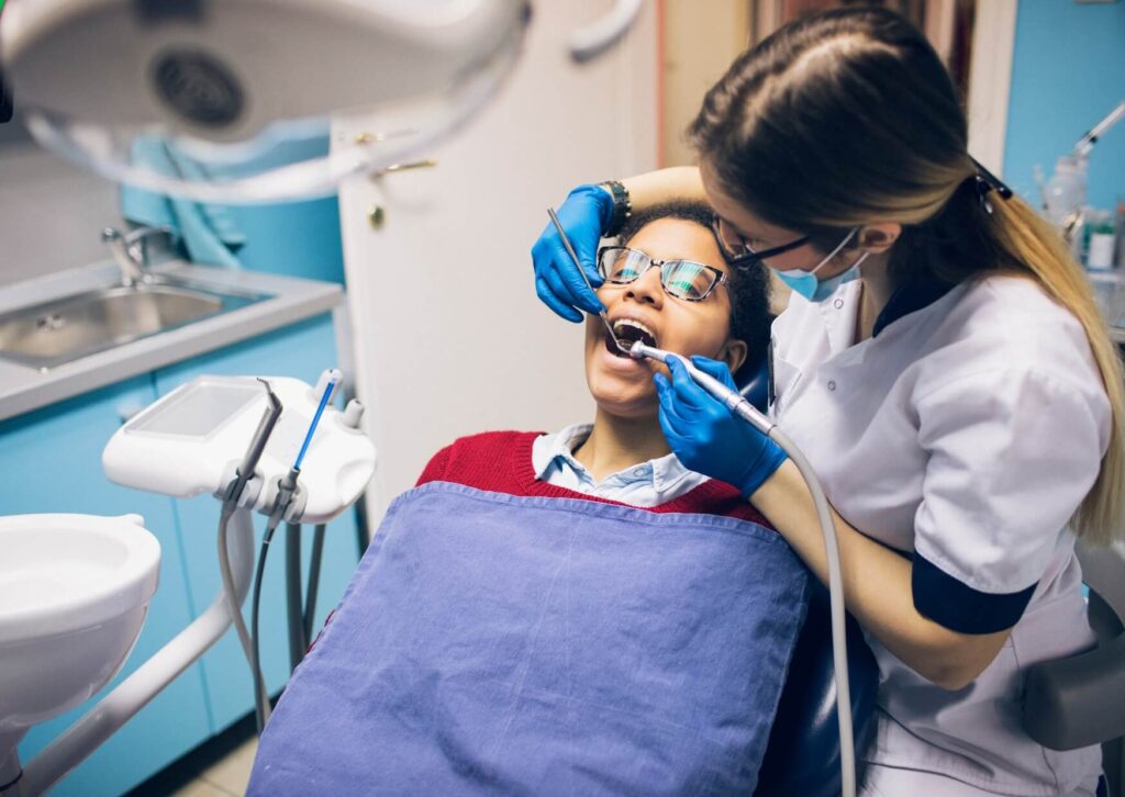 Dentist examining a patient's dental implant before evaluating whether dental implant removal is necessary.