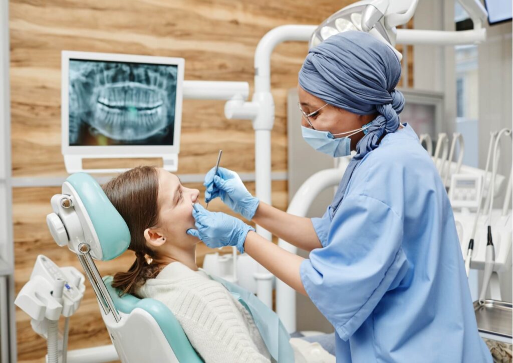Dentist examining a patient's mouth to evaluate an erupting wisdom tooth and check how the wisdom tooth is coming in.