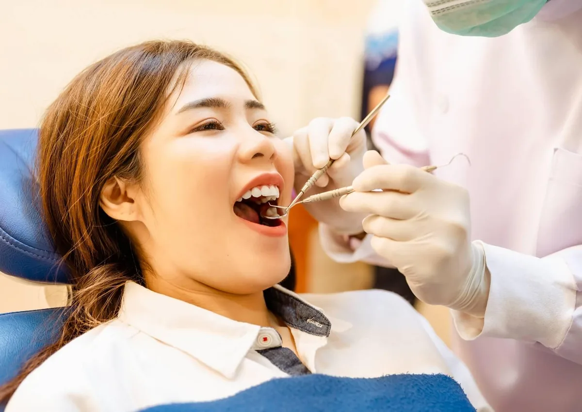 Patient receiving a dental exam before dental sealants are applied to protect the chewing surfaces of molars.