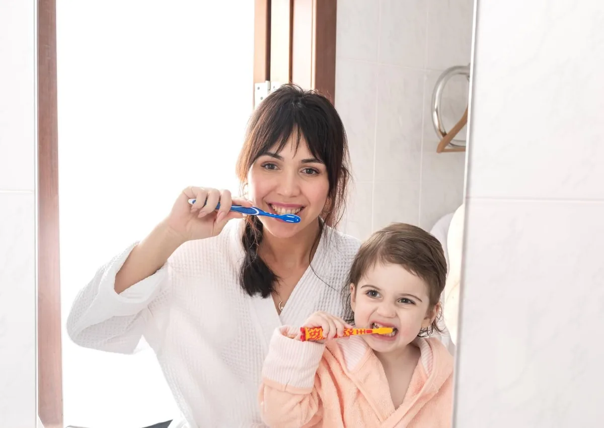 Mother and child brushing their teeth to help prevent cavities and tooth decay.