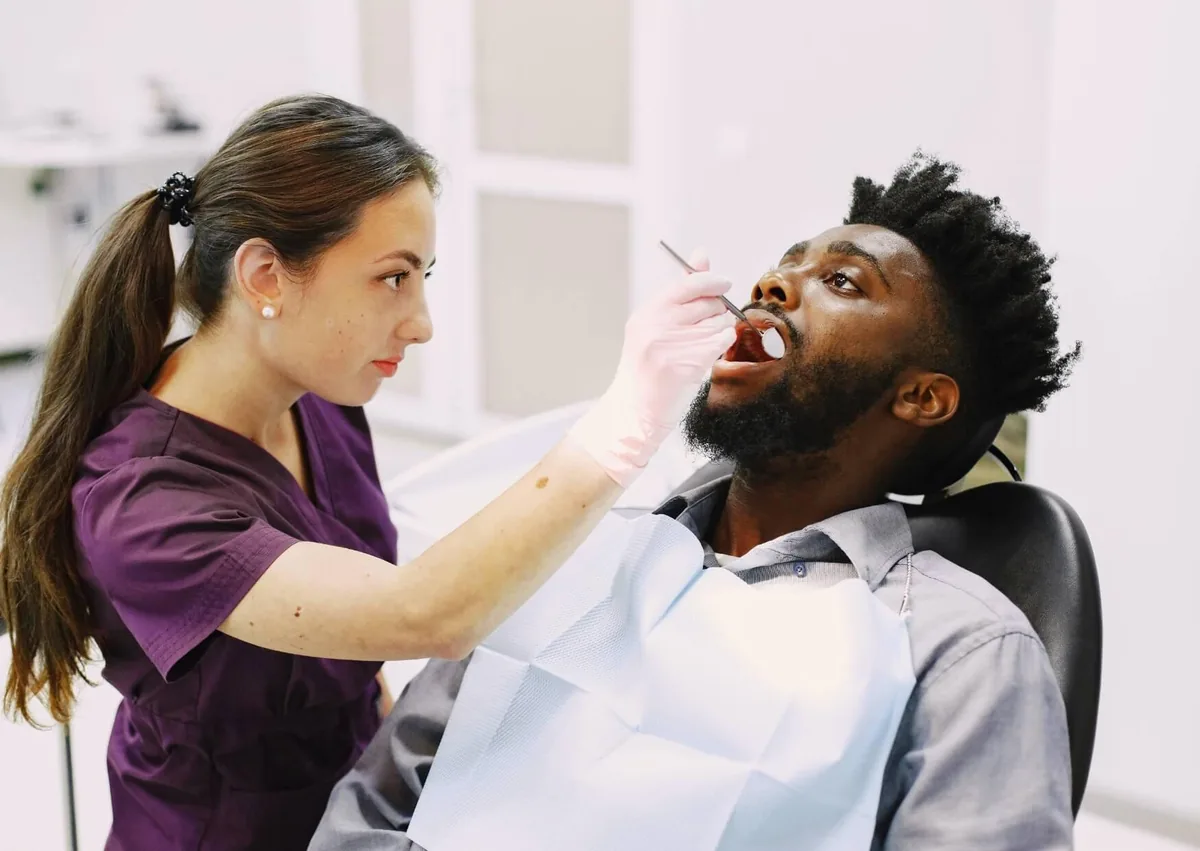 Dentist examining a patient’s mouth before wisdom teeth removal and discussing post-surgery eating guidelines.